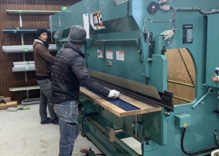 大阪市ベランダ笠木交換工事で笠木を曲げている様子