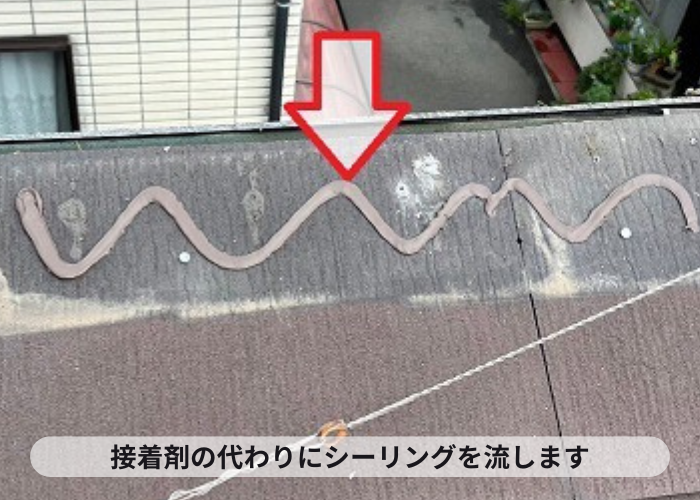 高槻市でのカラーベスト屋根部分修理でカラーベスト屋根を接着するためのシーリングを流している様子