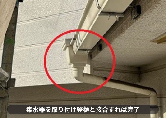 雨樋交換工事で集水器を取り付け竪樋と接合している様子