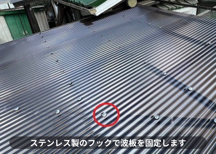 ガレージ屋根のポリカ波板をステンレス製のフックで固定している様子