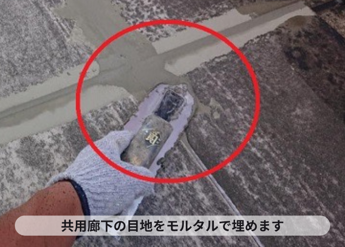 共用廊下のリフォームで目地を埋めている様子