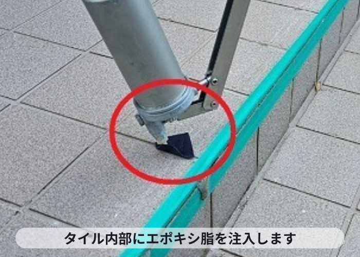 吹田市での玄関前タイル補修で内部にエポキシ樹脂を注入している様子