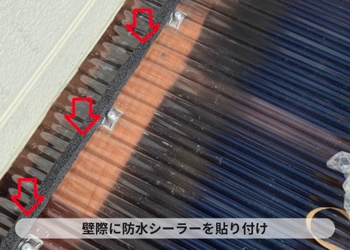 壁際に防水シーラーを取り付けている様子