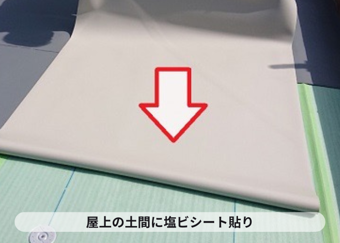 屋上の土間に塩ビシートを貼っている様子