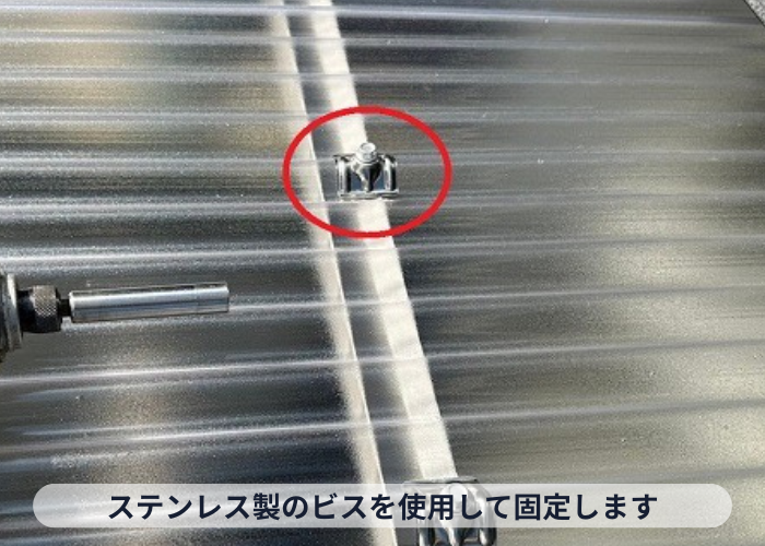 枚方市ストックヤードの屋根交換でステンレス製のビスでポリカ波板を固定している様子