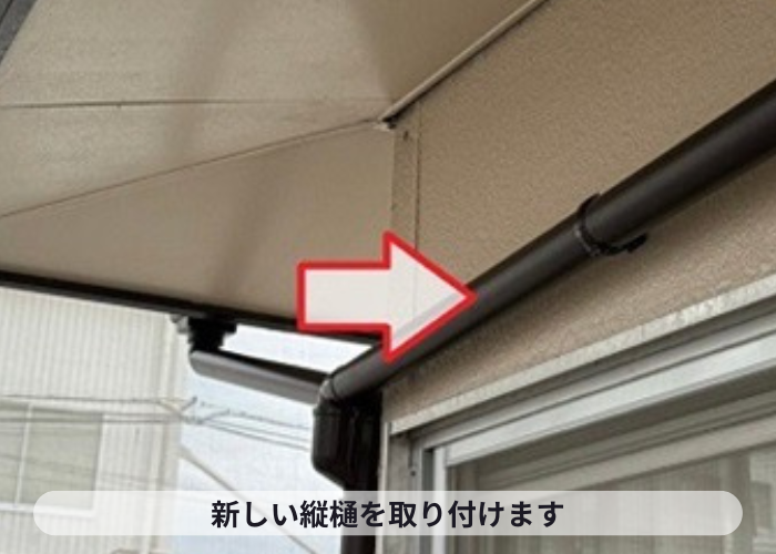 高槻市　　雨樋工事で新しい竪樋を取り付けている様子