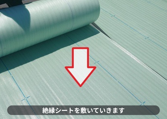 豊中市で屋上の雨漏り修理として塩ビシート防水機械固定工法で絶縁シートを敷いている様子