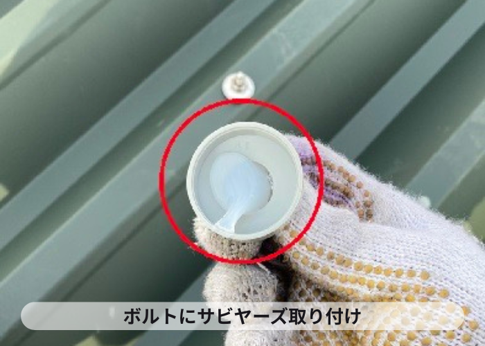 折半屋根のボルトにサビヤーズを取り付けている様子
