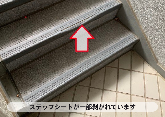 共用階段のステップシートが一部剥がれている様子
