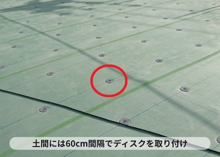 マンション屋上防水工事の塩ビシート機械固定工法でディスクを取り付けている様子