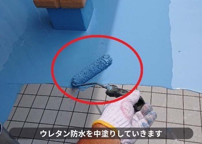 池田市ウレタン防水をベランダ床に中塗りしている様子