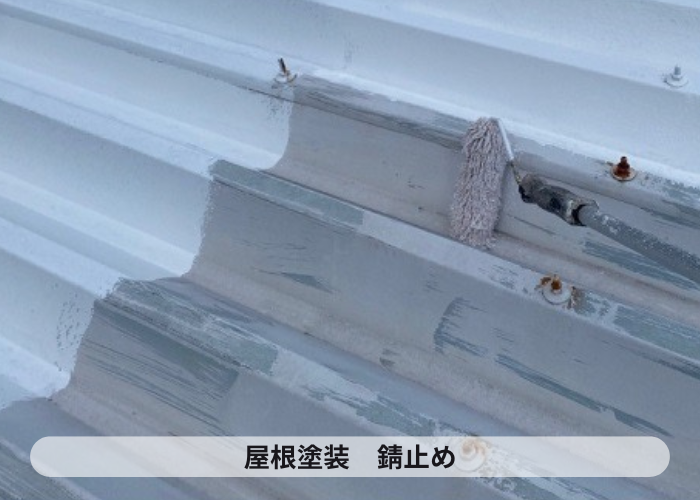 折半屋根に錆止め塗装を行っている様子