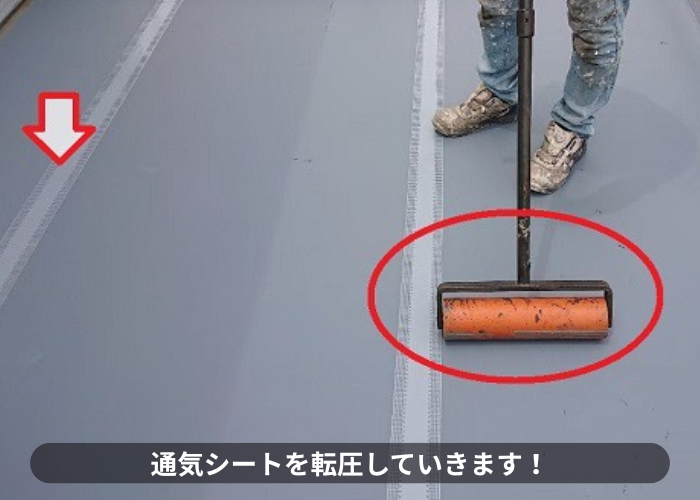 豊中市ウレタン防水工事で通気シートを転圧している様子