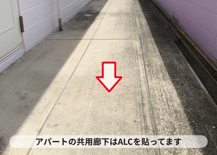 アパートの共用廊下にALCを貼っている様子