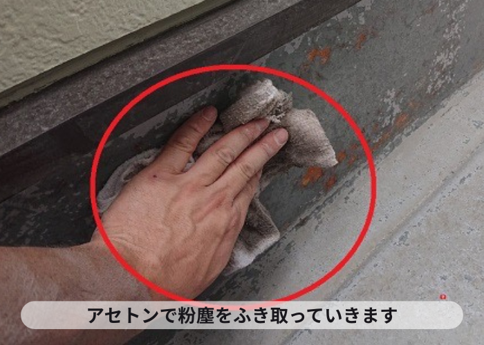 剥がれたベランダ防水の表面をアセトンで拭き上げている様子