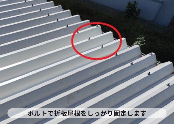 車庫の折板屋根をボルトで固定している様子