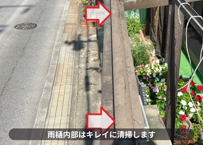 ガレージ屋根の雨樋内部を清掃している様子