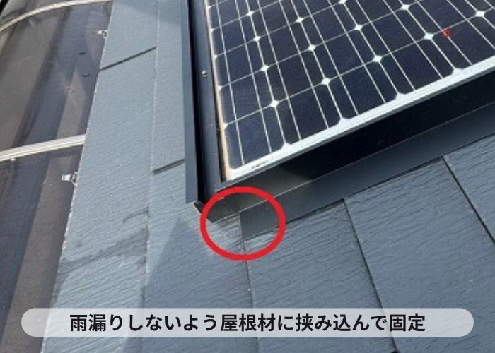 鳩除け対策で板金を屋根材に挟み込んでいる様子