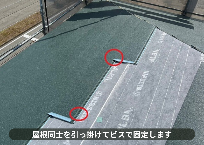 吹田市　3階建てスレート屋根への重ね葺き工事で屋根材をビス止めしている様子