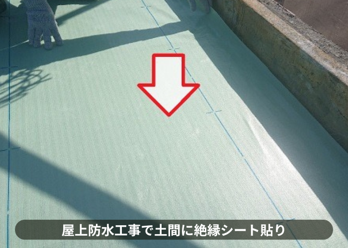 吹田市での屋上防水工事で絶縁シートを貼っている様子
