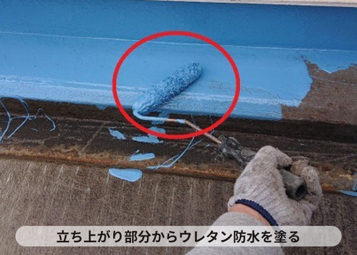 大阪府吹田市　陸屋根防水工事で立ち上がり部分にウレタン防水を塗っている様子